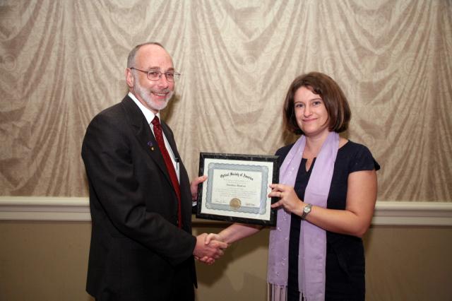 Susana receiving the OSA Fellow Certificate from OSA President Thomas M. Baer